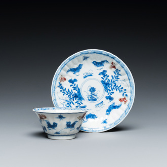 A Chinese blue, white and copper-red cup and saucer, Kangxi