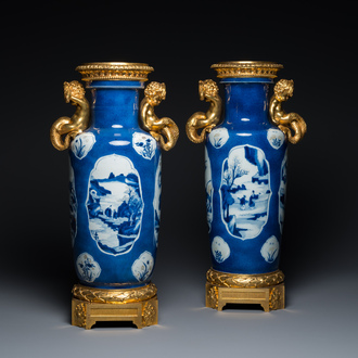 Een paar Chinese rouleau vazen met blauw-wit en koperrood decor op poederblauwe fondkleur met fijne monturen in vuurverguld brons, Kangxi en 19e eeuw