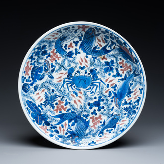 Plat en porcelaine de Chine en bleu, blanc et rouge de cuivre à décor de poissons et d'un crabe, Kangxi