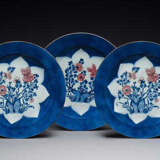 Trois grands plats en porcelaine de Chine en bleu, blanc et rouge de cuivre à décor floral sur fond bleu poudré, Kangxi