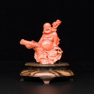 Een Chinese bloedkoralen figuur van een lachende Boeddha op houten sokkel, 19/20e eeuw