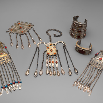 Two silver bracelets, two pendants with carnelian stones, a silver back ornament and a silver capstone, Turkmenistan, 19/20th C.