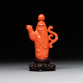A Chinese carved red coral ewer and cover on wooden stand, 19th C.