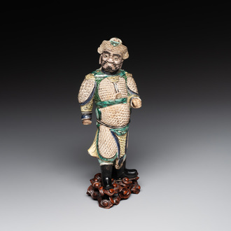 A fine Chinese verte biscuit figure of a warrior on wooden stand, Kangxi
