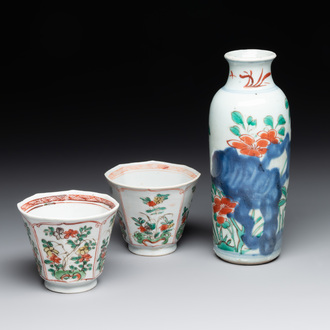 A Chinese wucai rouleau vase and a pair of octagonal cups with floral design, Transitional period/Kangxi