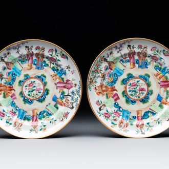 A pair of Chinese Canton famille rose plates with figures in a garden, 19th C.