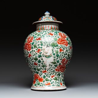 A Chinese wucai 'boy and peony scroll' vase and cover, 17th C.