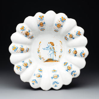 A yellow, blue and white Dutch Delftware dish with a putto playing the violin, Delft or Haarlem, dated 1642