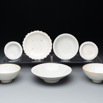 Four Chinese white-glazed saucers and three bowls, Yuan/Ming