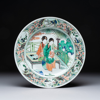 A Chinese famille verte dish with two ladies and a boy holding a lotus, artemisia leaf mark, Kangxi