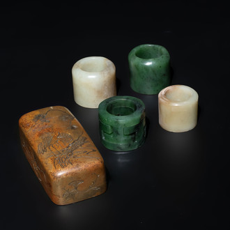 Four Chinese white and spinach-green jade archer rings and a bronze box with a crane design, 19th C.