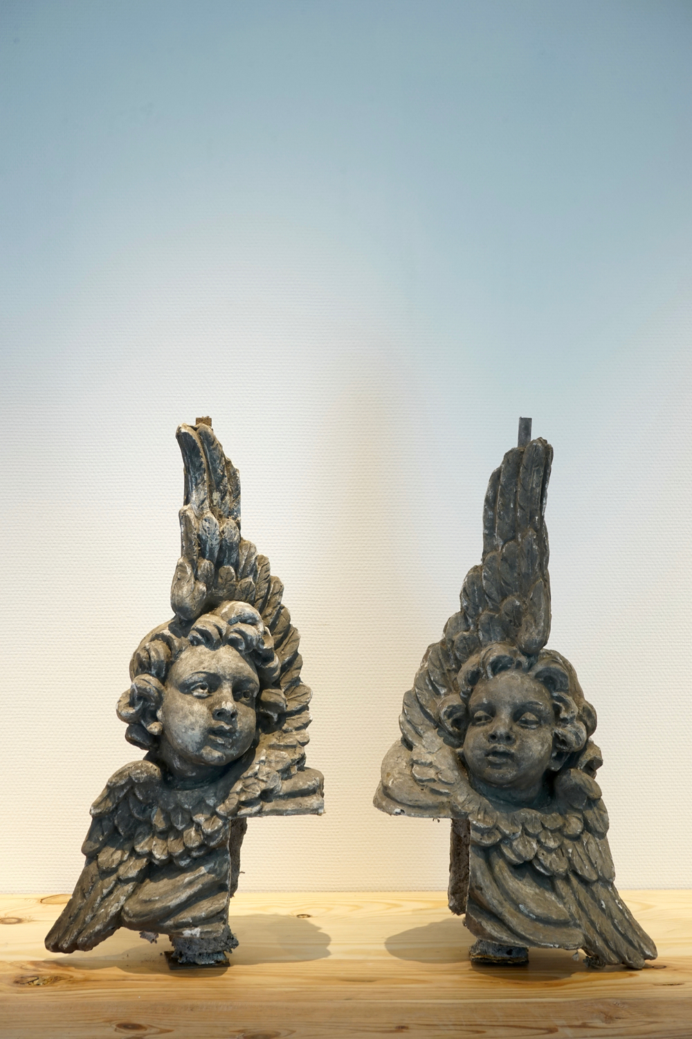 A set of two plaster casts of winged cherubs en pendant, 19/20th C., Bruges