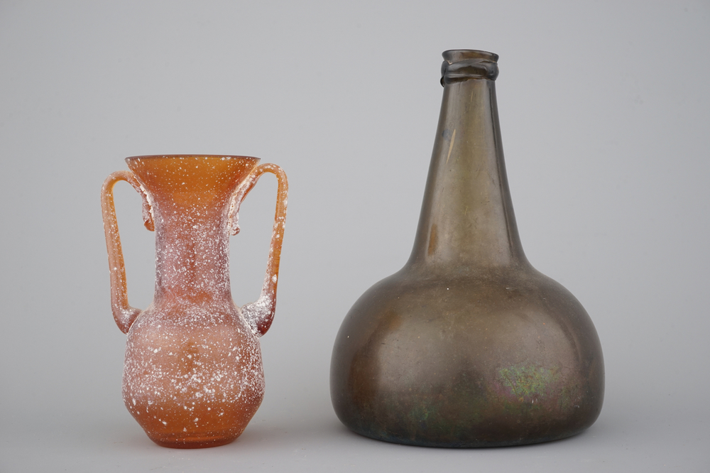 Een wijnfles in groen geblazen glas, 18e eeuw en een amphora in oranje glas naar antiek voorbeeld