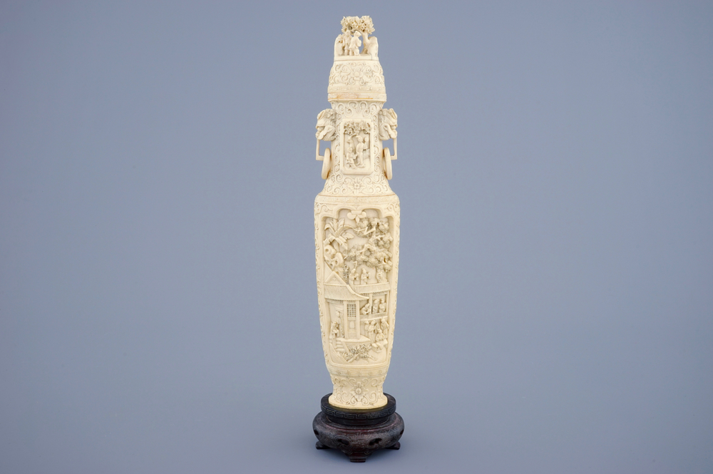 A Chinese carved ivory vase and cover on a wooden base, early 20th C.