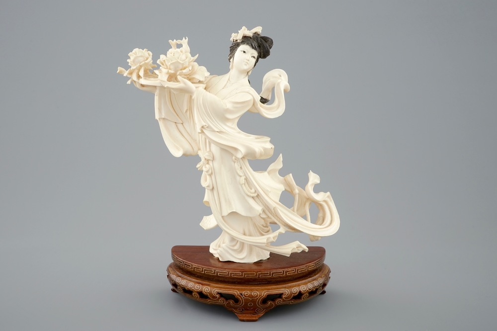 A Chinese carved ivory figure of a dancer with flowers on base, 1st half 20th C.