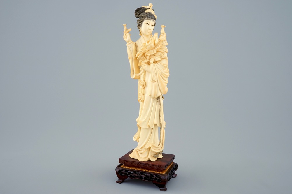 A Chinese carved ivory figure of a lady on wooden base, early 20th C.