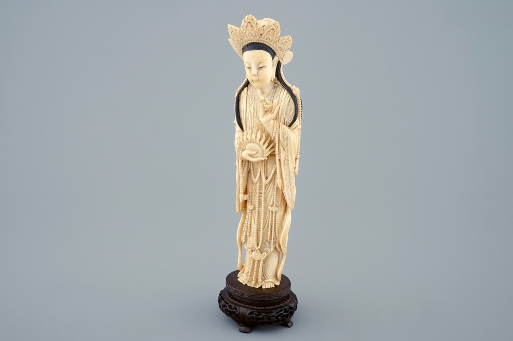 A Chinese carved ivory figure of Guanyin on wooden base, early 20th C.