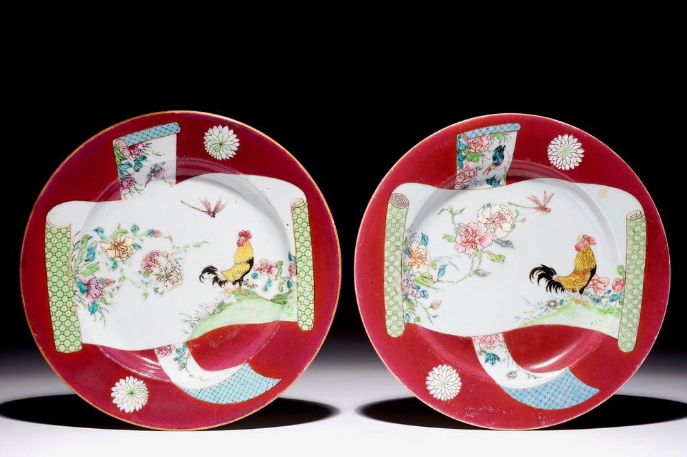 Une paire d'assiettes en porcelaine de Chine famille rose &agrave; d&eacute;cor de coqs sur fond rouge rubis, Yongzheng