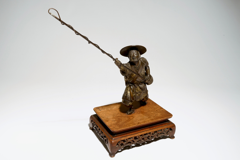 A Japanese bronze model of a fisherman on wooden base, Meiji, signed