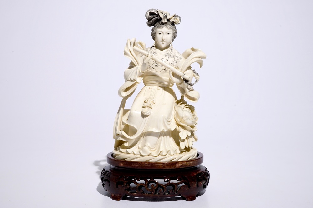 A Chinese ivory figure of a lady playing a flute on wooden base, early 20th C.