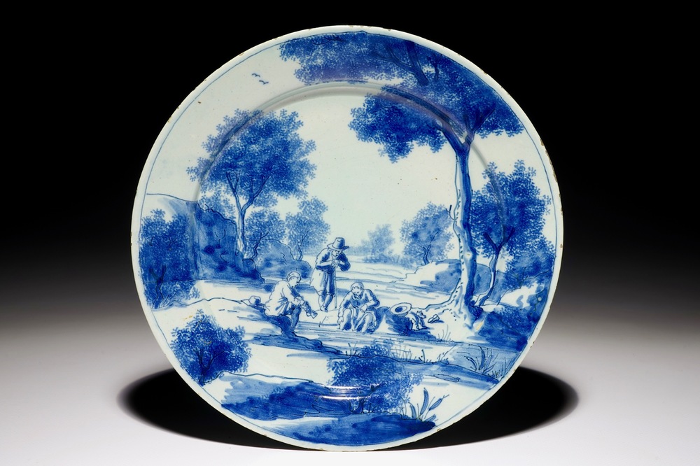 Een fijn blauw-wit Delfts bord met mannen bij een rivier, begin 18e eeuw
