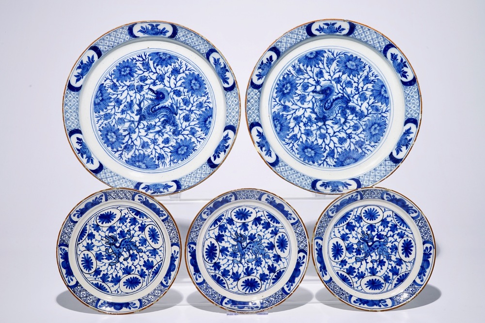 Een paar schotels en drie borden in blauw-wit Delfts aardewerk met chinoiseriedecor van draken, 18e