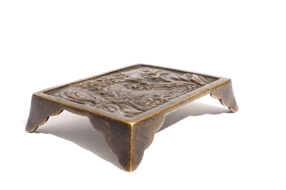 A Chinese relief-decorated bronze brush rest, Ming