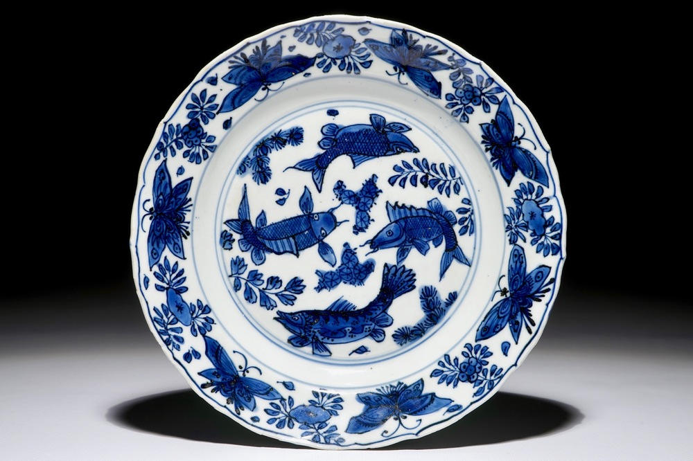 Een Chinees blauwwit bord met karpers en vlinders, Wanli