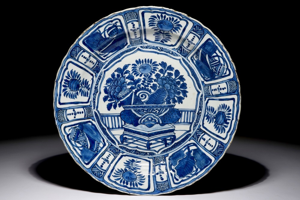 Un plat en porcelaine de Chine bleu et blanc de type Kraak &agrave; d&eacute;cor d'un vase fleuri, Wanli