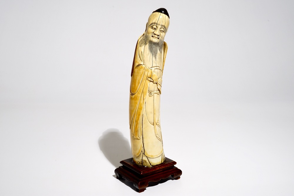 A Chinese ivory figure of the immortal Han Zhongli, on wooden base, late Ming