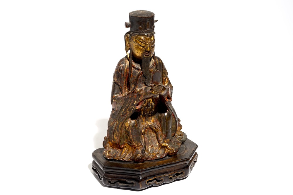 A Chinese partly gilt and polychrome bronze figure of Wenchang Dijun on wooden stand, Ming