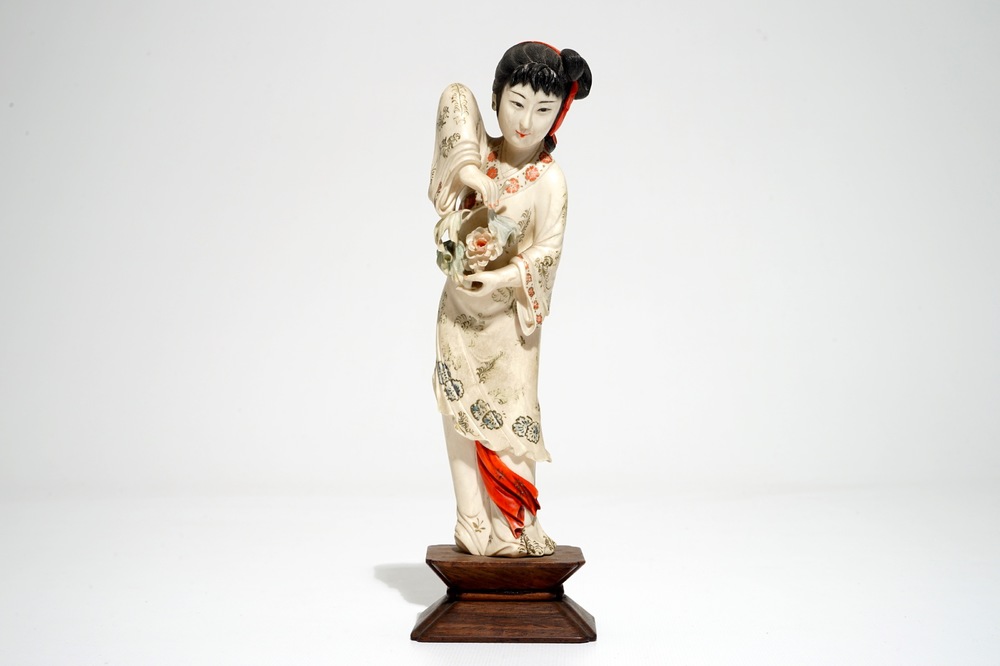 Een Chinese polychrome ivoren figuur op houten sokkel, 2e kwart 20e eeuw