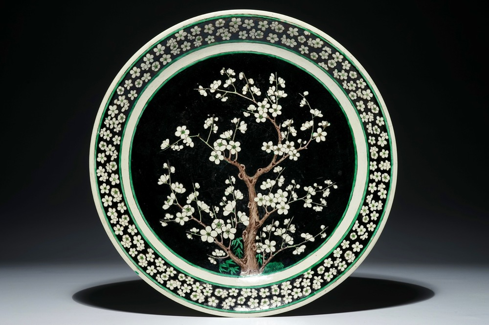 A Chinese famille noire biscuit prunus tree charger, Kangxi