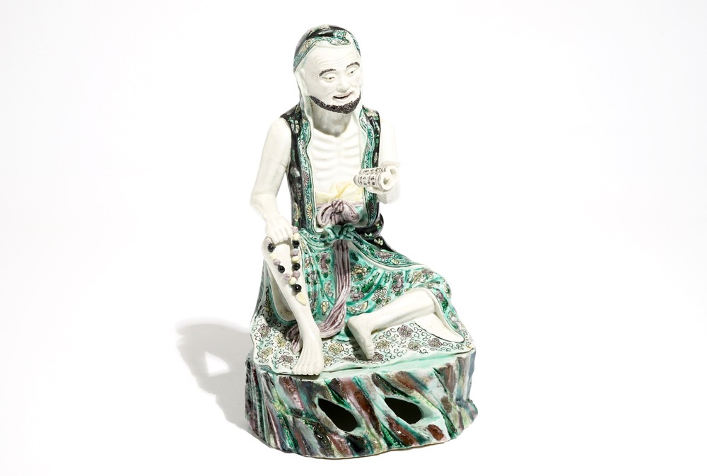 A Chinese verte biscuit model of a luohan with a scroll, Kangxi