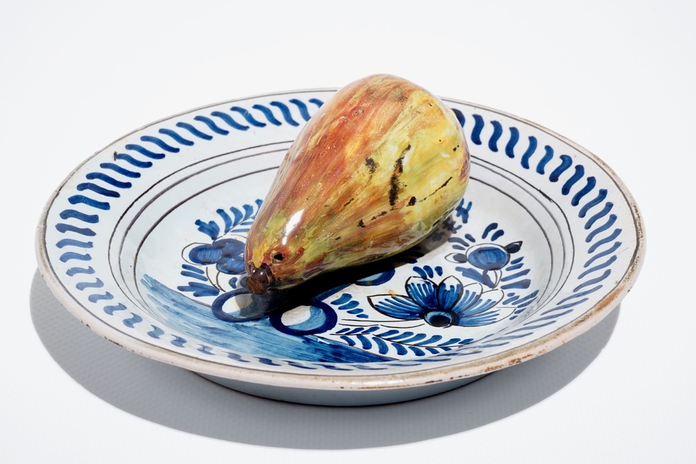 A polychrome Dutch Delft trompe l'oeil plate with a pear, 19th C.