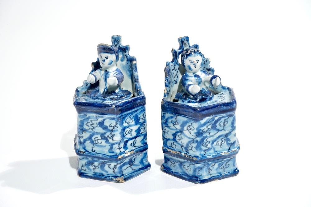 A pair of Dutch Delft models of seated children, 18th C.