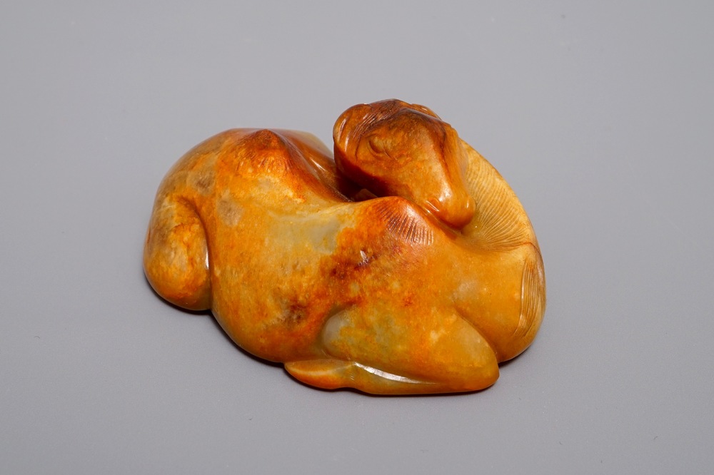 A Chinese carved russet jade model of a reclining horse, 19/20th C.