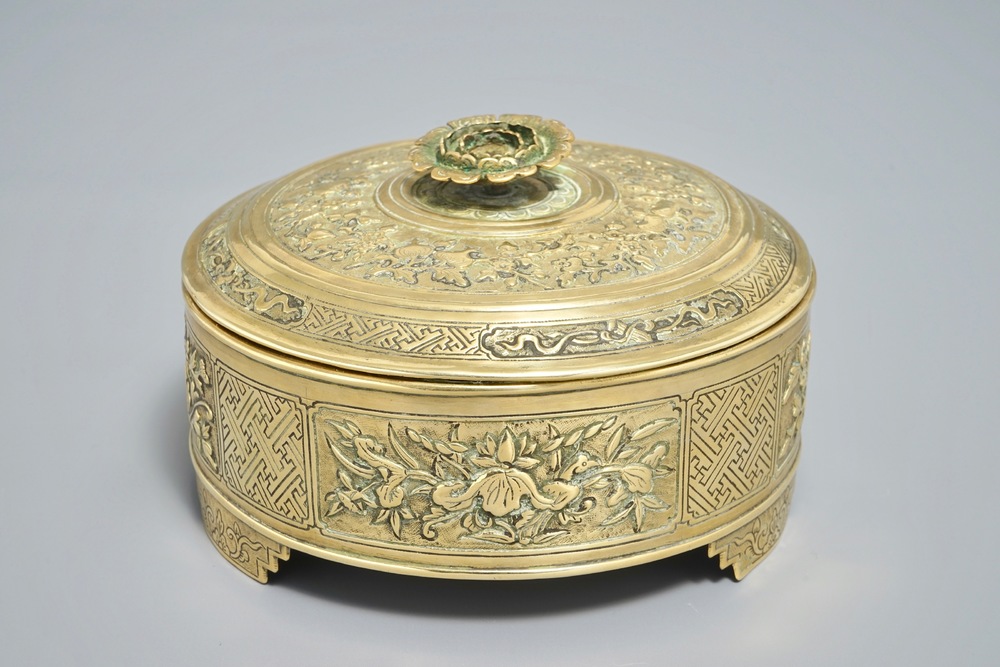 A round Chinese gilt copper-alloy box and cover with floral design, 18/19th C.