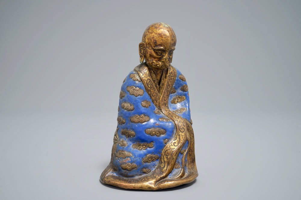 A Chinese champlev&eacute; enamel and gilt copper model of a Luohan, Qianlong