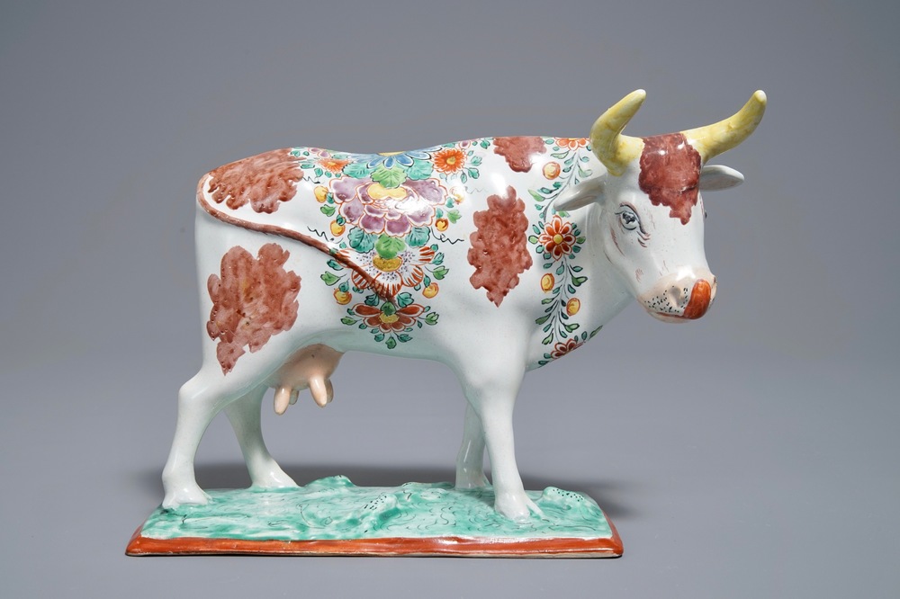 A polychrome Dutch Delft petit feu cow on base, 18th C.