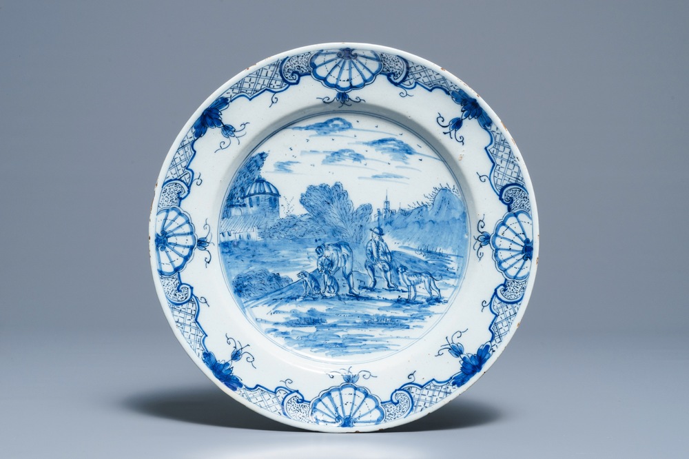 A Dutch Delft blue and white dish with figures in a landscape, 18th C.