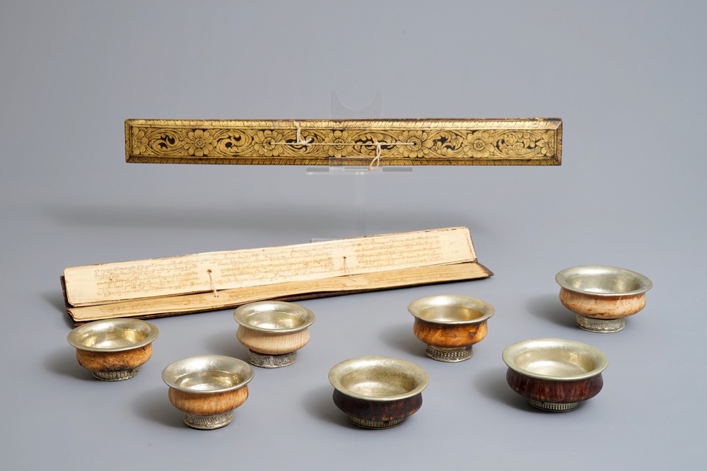 Seven burl wood and silver teabowls and two gilt wood encased Buddhist scriptures, Tibet, 19/20th C.