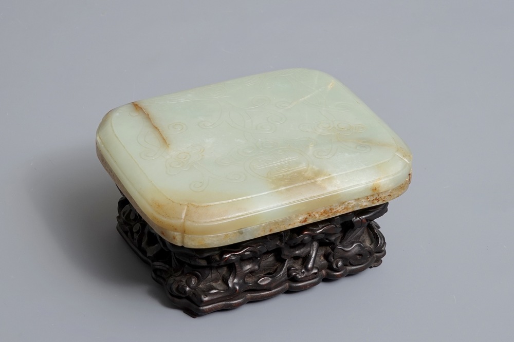 A Chinese celadon and russet jade box and cover on wooden stand, Ming/Qing