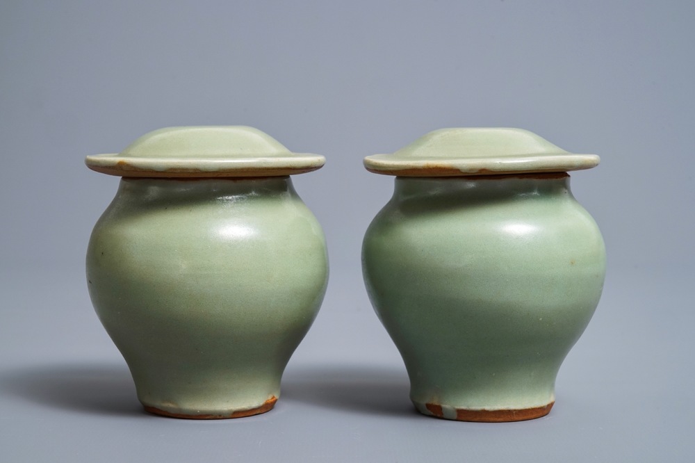 A pair of Chinese Longquan celadon vases and covers, Ming