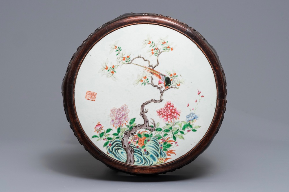 Une plaque en porcelaine de Chine famille rose dans un socle en bois, 19/20&egrave;me