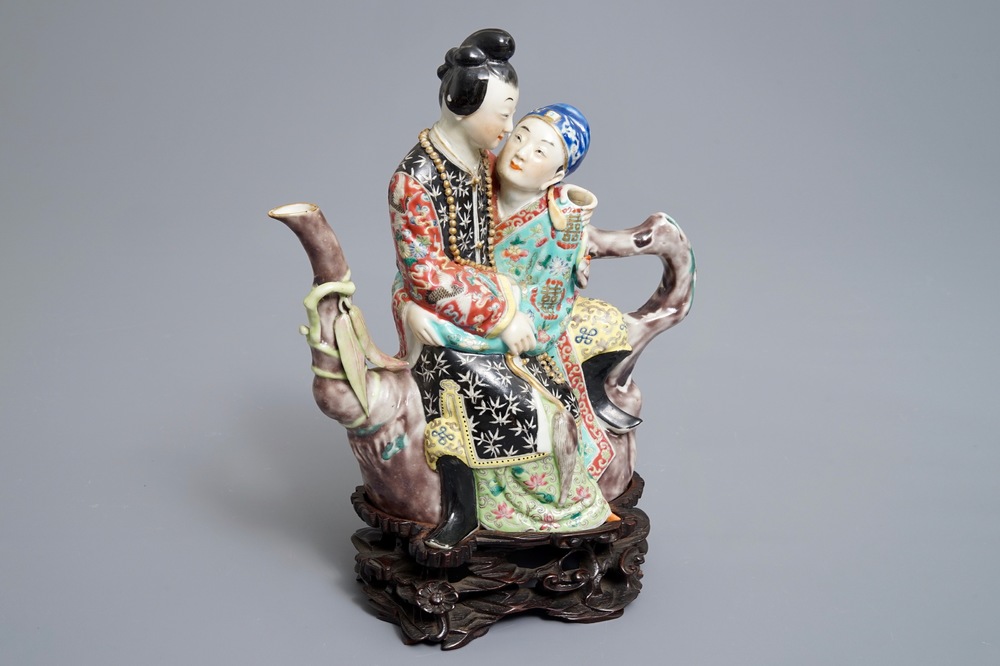 A Chinese famille rose semi-erotic teapot on wooden stand, Republic, 20th C.