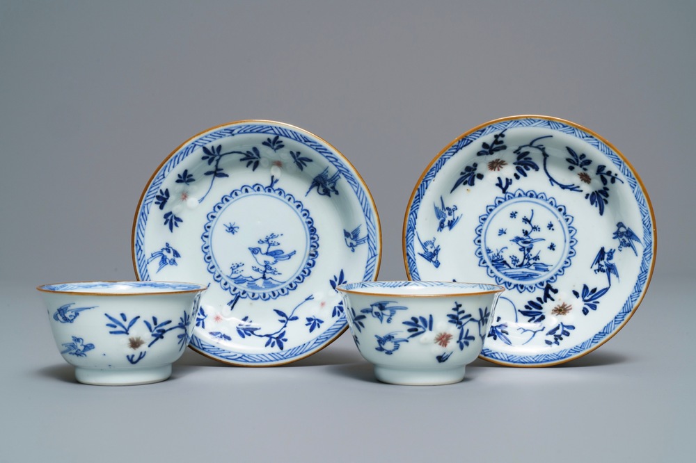 A pair of Chinese blue, white and underglaze red cups and saucers, Kangxi