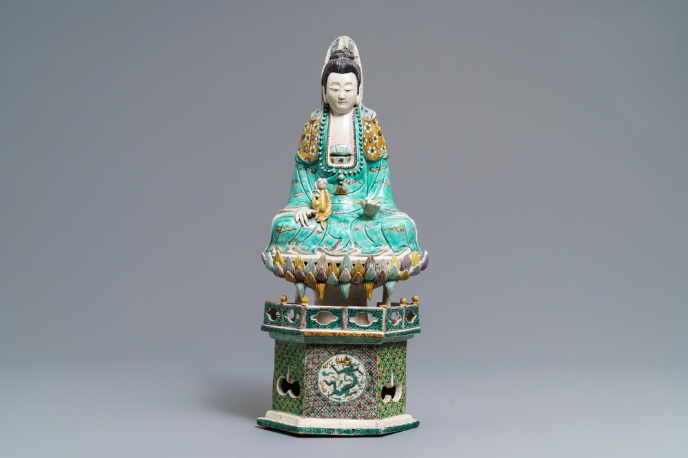 A Chinese verte biscuit group of Guanyin with child on a lotus throne, Kangxi