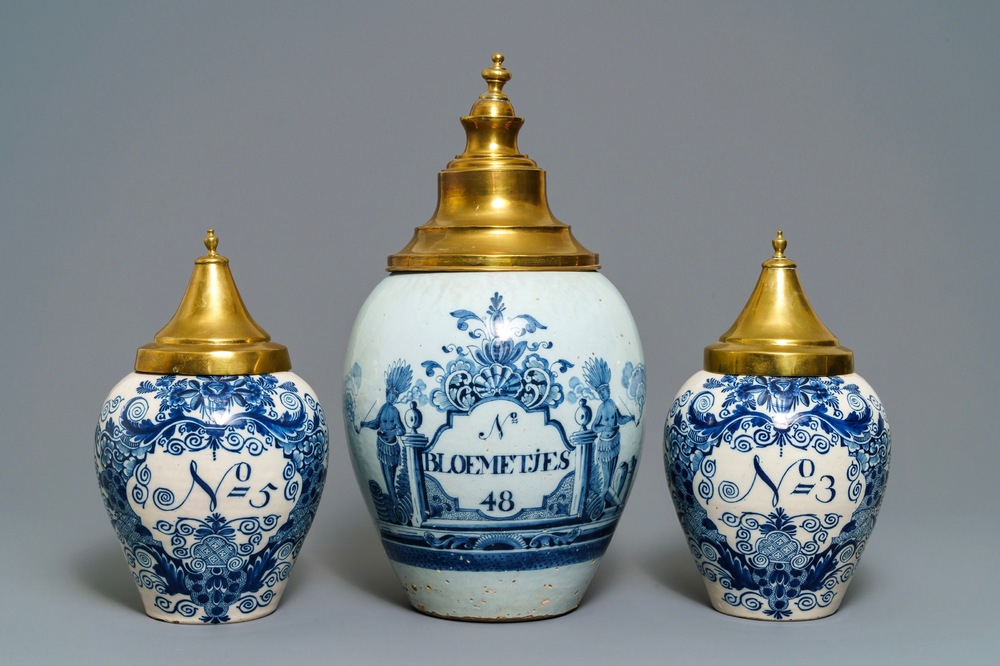 Three Dutch Delft blue and white tobacco jars with brass covers, 18th C.