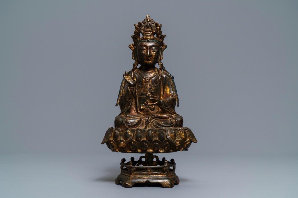 Een Chinese gelakt en verguld bronzen figuur van Guanyin op een lotustroon, Ming